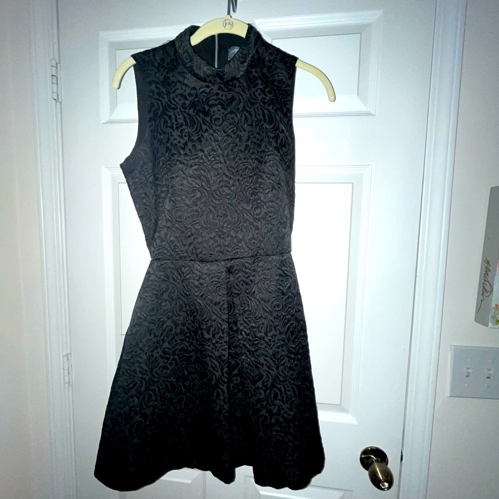 Designer black cocktail dress with subtle design and open back